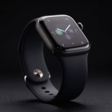 Apple Watch with a dark sport band, glowing screen, low-key lighting, macro details