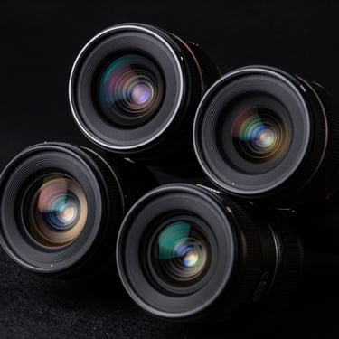 Macro shot of iPhone camera lenses, dark sleek studio lighting, reflections, black background