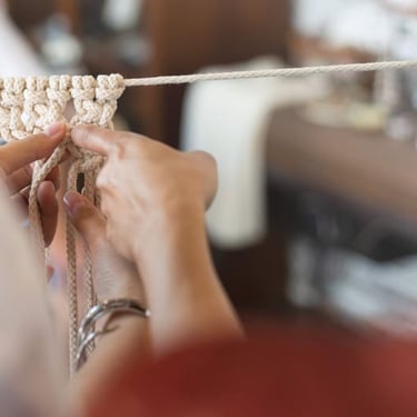 Manos tejiendo macramé