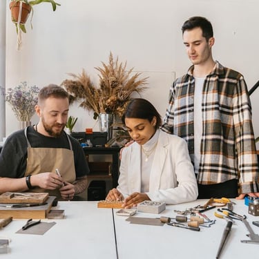 tres personas elaborando joyería artesanal con instrumentos especializados