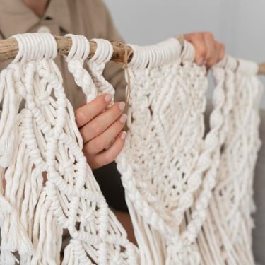 mujer sosteniendo adorno tejido con macramé a mano