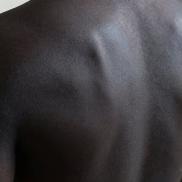 Extreme close-up of dark matte athletic coating, sharp light revealing structural integrity, heavy negative space