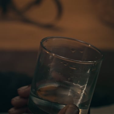 Close-up of a glass on a table in the short film Grief directed by Daniel da Trindade.