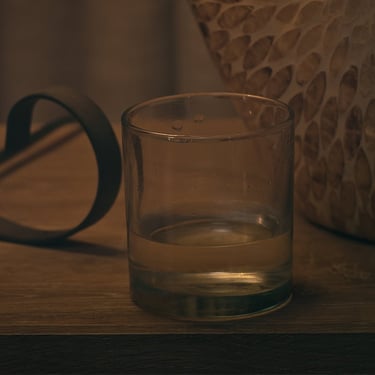 Glass resting on a table in a cinematic frame from the short film Grief.