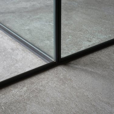 Detail shot of structural glazing meeting a raw concrete floor seamlessly