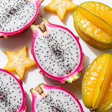 Sliced dragonfruit and starfruit flat-lay, showcasing rich internal textures and vibrant exotic colors under high-key sunlight