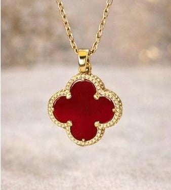 Collar de trebol rojo en un fondo suave