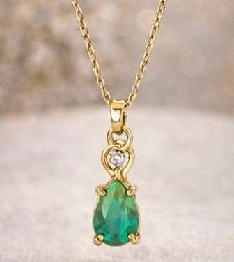 Collar con perla verde en un fondo blanco