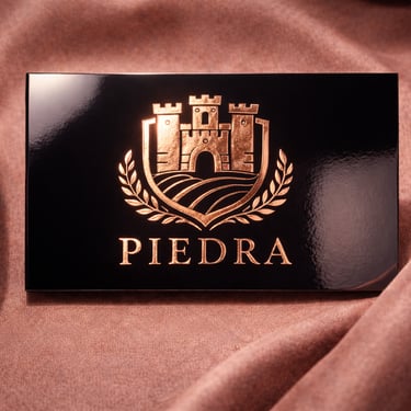 Dark card with copper metallic stamped logo in center