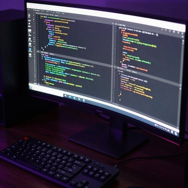 Extreme close-up of a high-end developer workstation in a dark room. An ultra-wide monitor displays clean, complex code blocks. Low-key ambient lighting with a sharp, high-voltage electric violet rim light reflecting off the hardware components.