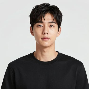 A man happily practicing English on his laptop in a bright, homey living room.