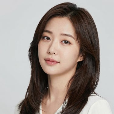 A man happily practicing English on his laptop in a bright, homey living room.