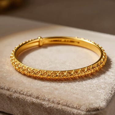 Macro shot of intricate gold bangles with delicate filigree work, resting on a soft velvet surface, dramatic side lighting