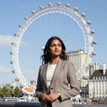 Portrait of a confident Indian female student aged around 25, smiling with a backpack in a university campus setting.