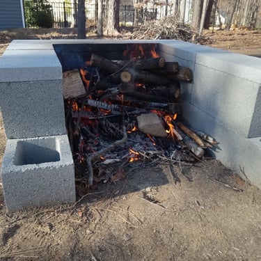Burning wood and logs in a cement block open fire pit