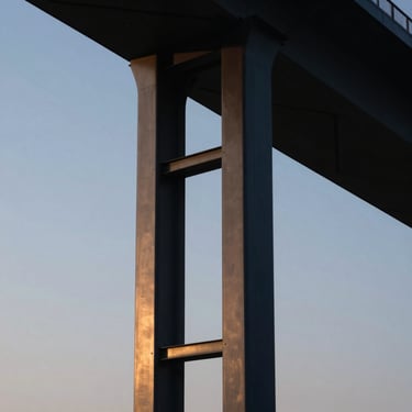 Abstract close-up of a modern steel structural column reflecting twilight sky, sharp architectural photography, deep navy tones
