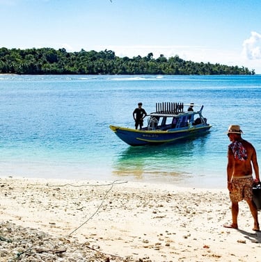 two men walking on the beach with a boat in the background