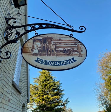 Cast iron pub sign with painting depicting former brewery staff