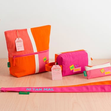 Handmade pink and orange canvas cosmetic bags and matching fabric leash on a wooden table.