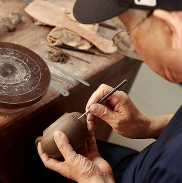 a man using a tool to make holes in a teapot