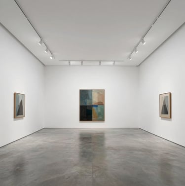 Wide view of the main hall of Galerie ZAXAPH Paris, high ceilings, white walls, polished concrete floor in #5F5B54, one central art piece, ultra-premium.