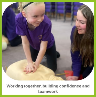 A child learning CPR on a manikin smiling at another child next to her