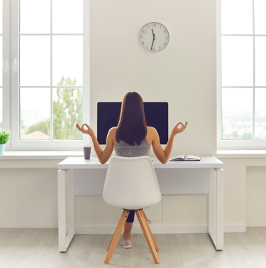 Image of a female working professional, working fr meditating on her desk, in front of her computer.