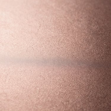Macro photography of a high-quality rose gold textured surface, uniform soft lighting, sophisticated and minimalist, clean sharp focus, European / Spanish luxury feel.