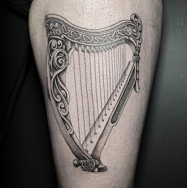 Tatouage d'une harpe celtique sur la cuisse.