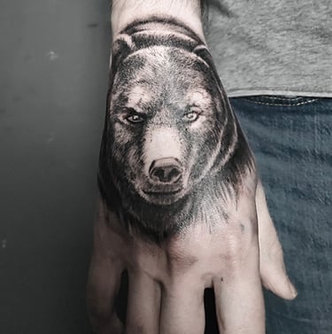 Tatouage d'une tête d'ours sur la mai,n.
