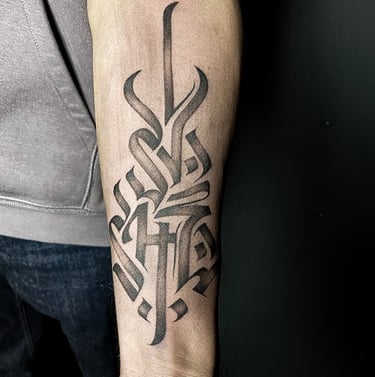 Tatouage d'un symbole typographique sur l'avant-bras.