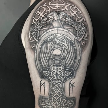 Tatouage sur le bras de Mjolnir, le marteau de Thor et d'un bouclier viking sur fond de Vegvisir.