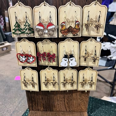 Wooden display fo handmade earrings with holiday and nature designs.