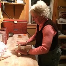 a woman in a red sweater and jeans, cooking