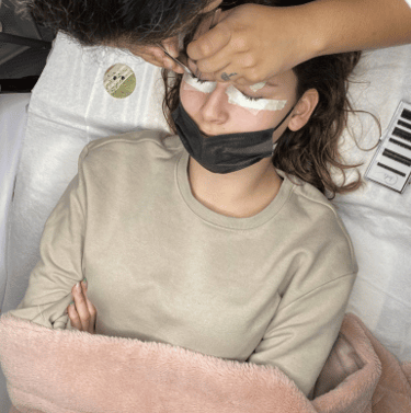femme recevant une pose de cils au salon Insia beaute 
