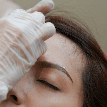 a woman getting her eyebrows done by a professional hairdresser