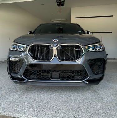 Front view of a grey BMW X6 M Competition SUV after a hand wash and detail.