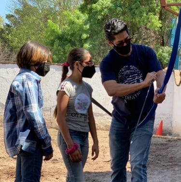 a man teaching arqueria ecuestre to two kids