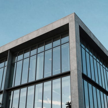 A minimalist architectural detail of a modern South American / Brazilian building with clean lines and Steel Blue glass panels, reflecting a bright and clear sky.