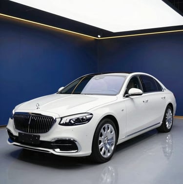A wide angle shot of a pristine luxury sedan in a professional detailing studio with navy blue walls and golden accent lighting, emphasizing its flawless finish.