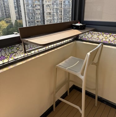 Narrow balcony with folding furniture, vertical plants, and warm lighting for a comfortable small ou