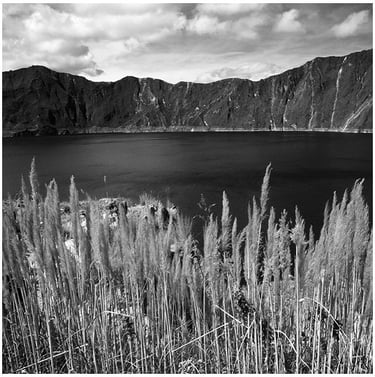 Ecuador: a lake with tall grass and mountains in the background