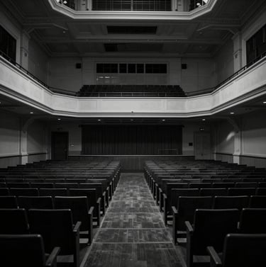 Wide angle photography of an empty, historic concert hall in Western European / Dutch style, dramatic architectural shadows in anthracite and black, elegant minimalist perspective, professional photography style.