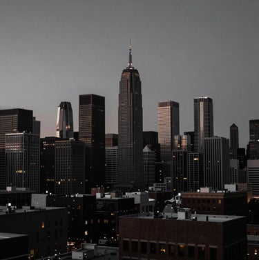 A wide, dramatic shot of a North American / US urban skyline at dusk, captured in slate gray and rich black tones, cinematic and mysterious.