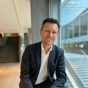 Andreas Frank – Interim CFO von Frankly Management Services – im Business-Outfit in Bürogebäude