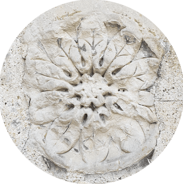 A 12-fold rosette of leaves in masonry, set roughly in mortar.