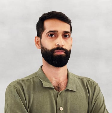 Portrait of VISUALISE founder in green shirt, light gray background.
