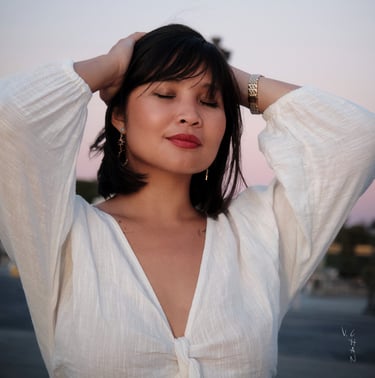 Modèle femme brune avec une chemise blanche sur un fond de ciel le soir