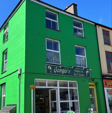 Georegio's shop front. Prominent green building in Llanberis High Street.