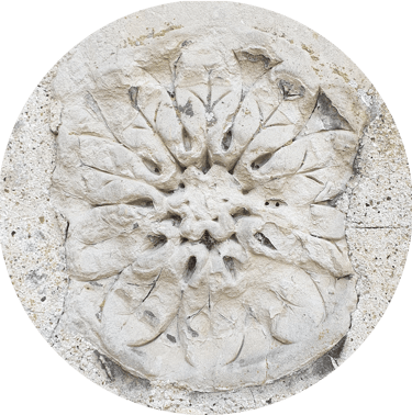 A 12-fold rosette of leaves in masonry, set roughly in mortar.